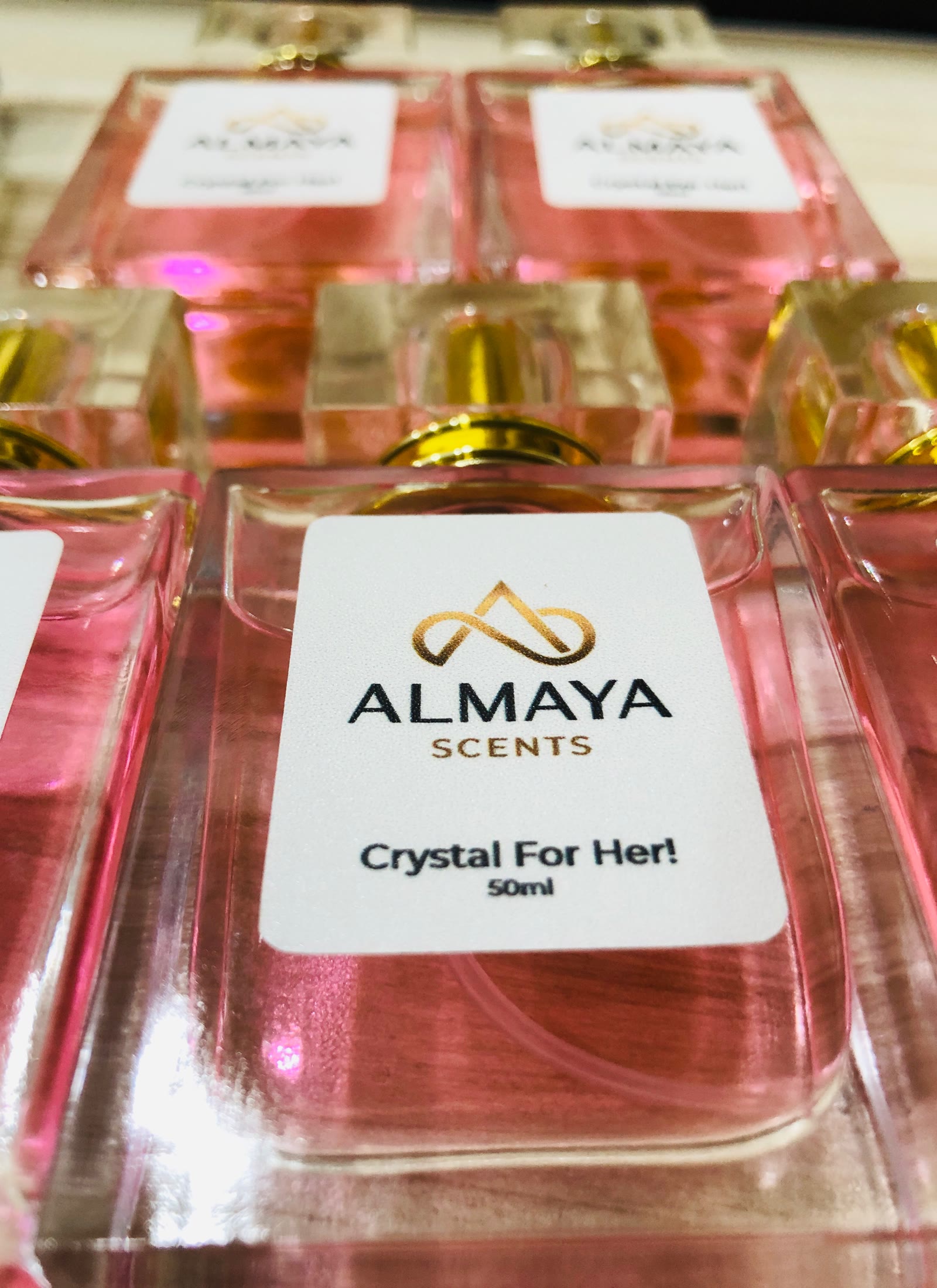 Close portrait of Crystal For Her bottles in soft pink light