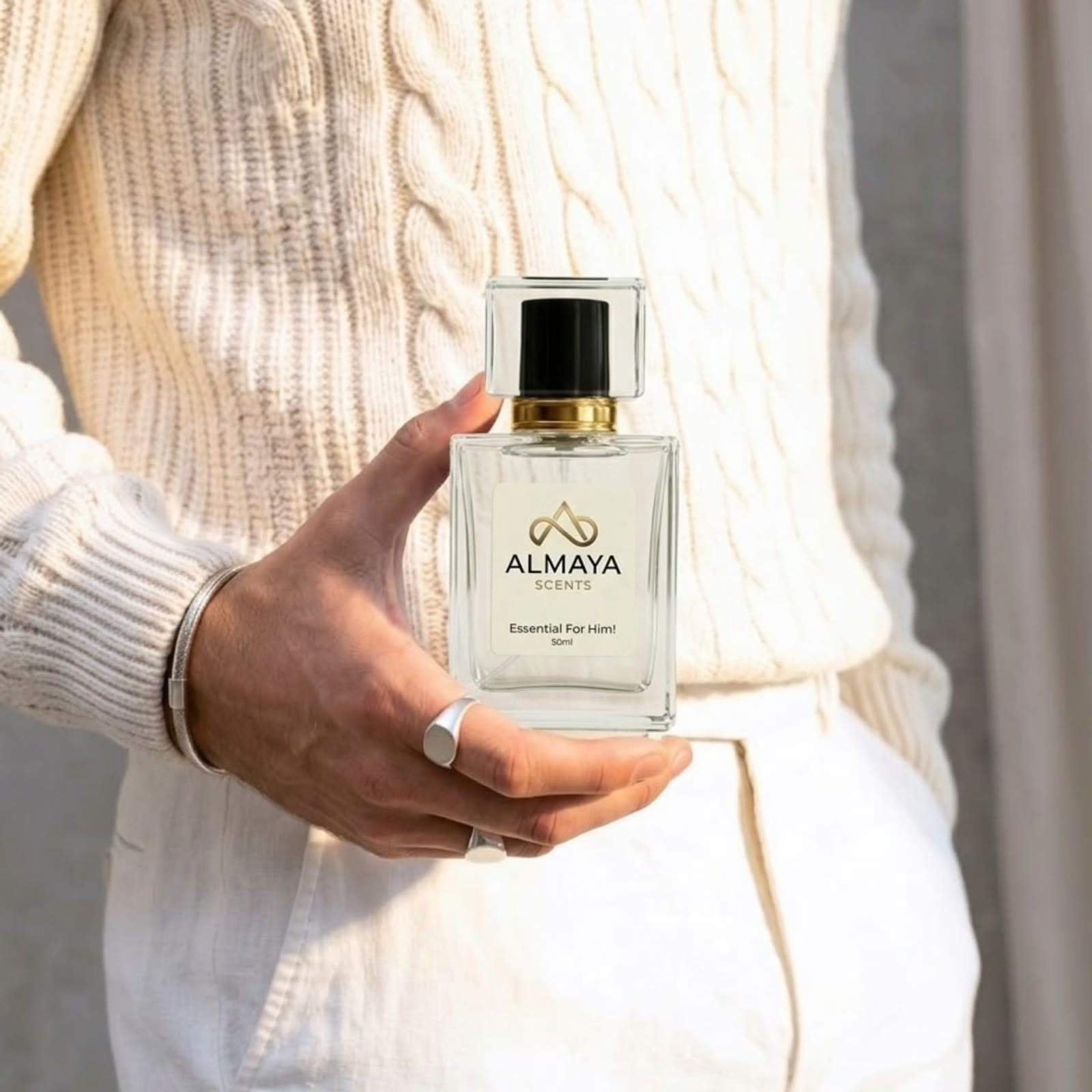 Essential For Him held against a cream cable-knit sweater